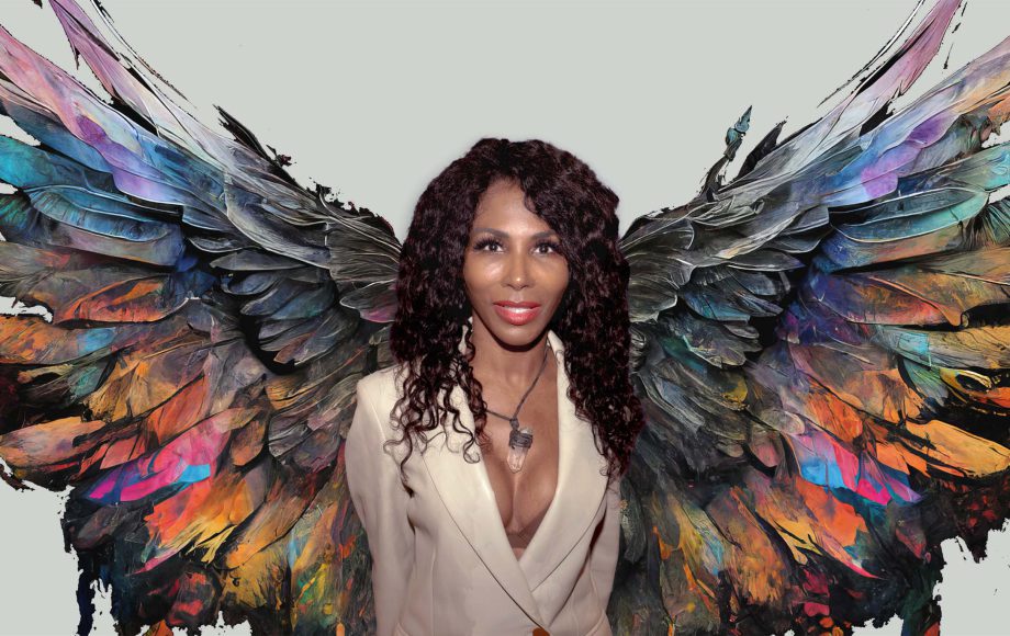 sinitta stood in front of colourful angel wings