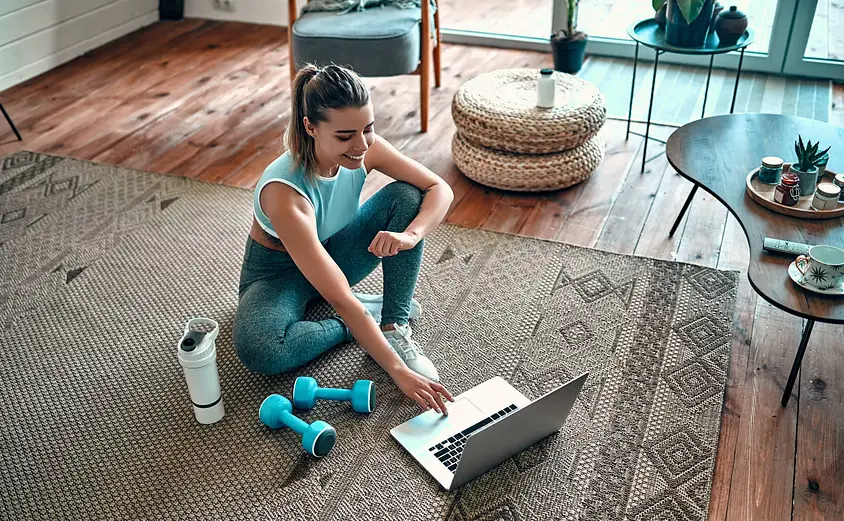 Woman-in-gym-wear-looks-at-laptop