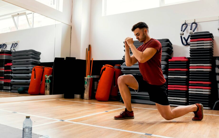Man-performs-lunge-in-gym