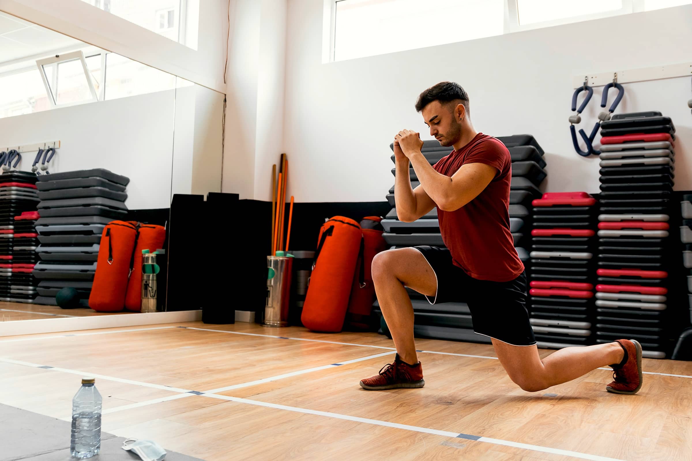 Man-performs-lunge-in-gym